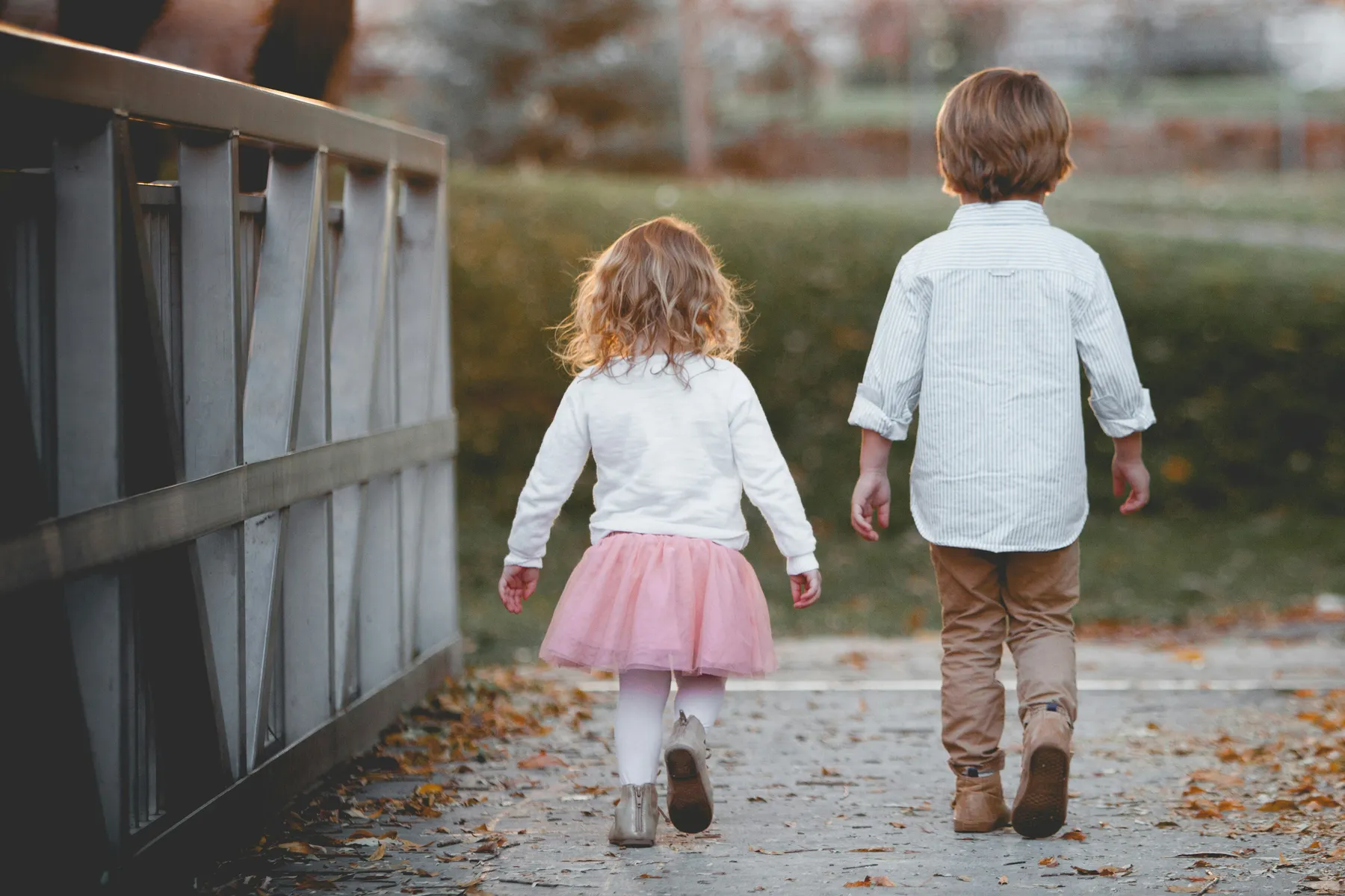 Deux enfants marchent ensemble sur un petit pont