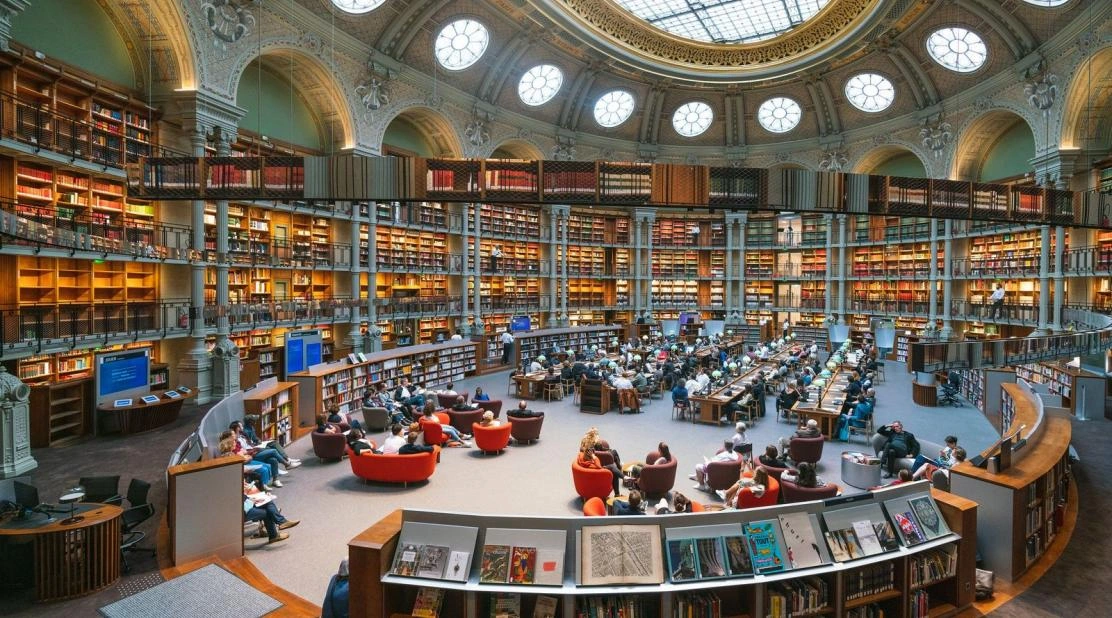 La salle Ovale de la BnF, ses rayonnages et ses lecteurs sous la verrière